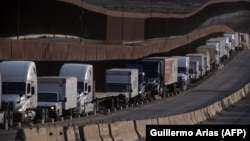 Trucks line up next to the border before crossing into the United States near Tijuana, Mexico.