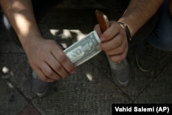 An Iranian street money changer holds a U.S. banknote in downtown Tehran earlier this month.