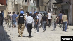 UN observers inspect a residential area with Free Syrian Army gunmen in the Talbisah area of Homs.