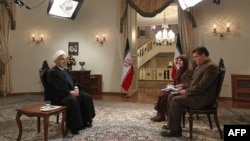 Iranian President Hassan Rohani (left) during an interview broadcast live on state television in Tehran on February 5.