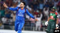 Rashid Khan (left) celebrates the wicket during the first Twenty20 International cricket match between Afghanistan and Bangladesh at Rajiv Ghandi International Cricket Stadium in Dehradun on June 3. 