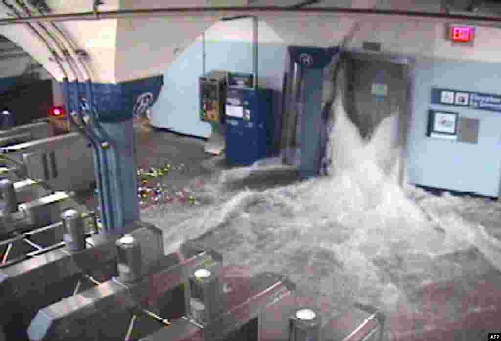 Flood waters rush into the Hoboken PATH train station through an elevator shaft in Hoboken, New Jersey.