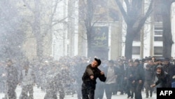 Antigovernment protesters throw stones at Kyrgyz policemen and servicemen in Bishkek on April 7, 2010.