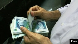 An Iranian man counts rials.