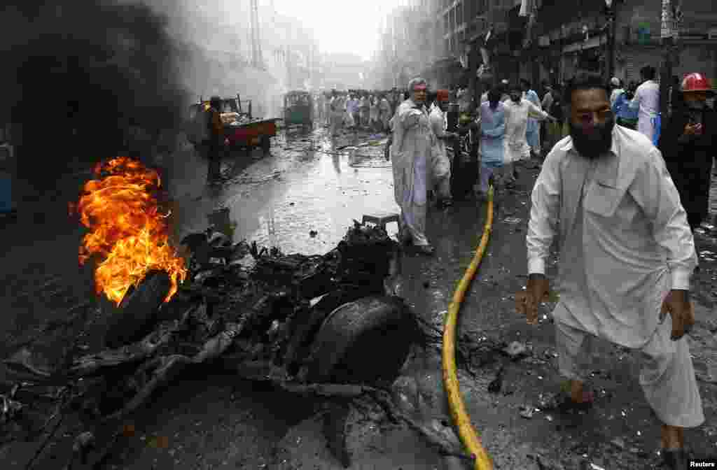 Rescue workers and residents gather at at the site of the midday bomb attacks.