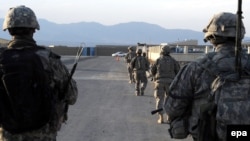 In this U.S. military handout photo, U.S. Army soldiers from Provincial Reconstruction Team-Paktika walk down a street in Sharana, in Afghanistan's Paktika Province, in 2009.