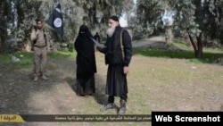 Islamic State released this image showing a woman being stoned to death for adultery after being "convicted" in a Shari'a court.