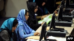 Election workers count votes at their computer terminals at the Independent Election Commission headquarters in Kabul.