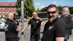 Some of the demonstrators wore black shirts branded with "Defensive West MG."