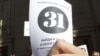 An opposition party supporter holds up a leaflet with the number '31' on it during a protest rally in Moscow 