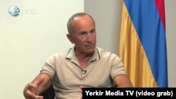 Former Armenian President Robert Kocharian being interviewed after he was charged with crimes.