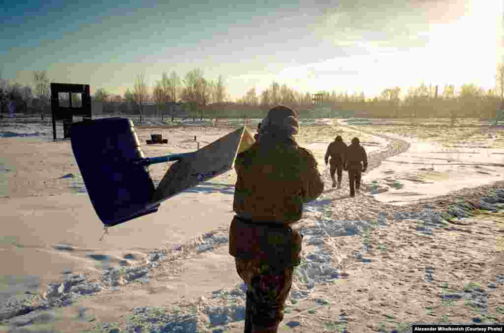 Soldiers spend the day clearing snow off the shooting range using a plywood contraption seen here.