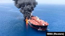 Smoke rises from an oil tanker in the Gulf of Oman after an explosion hit the vessel.