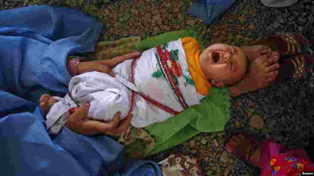 An Afghan infant is held by its mother as they wait to go back to Afghanistan from a UN-funded repatriation center in Pakistan.