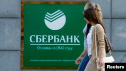 Women walk past a Sberbank office in Moscow on September 12.