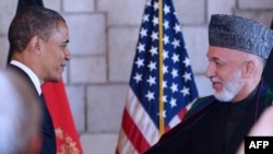 Afghan President Hamid Karzai (right) shakes hands with U.S. President Barack Obama after signing a strategic partnership agreement in Kabul.