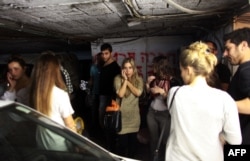 Israelis take cover in a bomb shelter in central Tel Aviv as sirens wail on November 16.