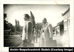 Men waiting at a tram stop.