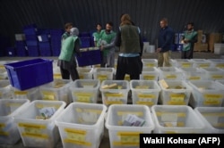 Afghan employees of the Independent Election Commission load biometric devices in to boxes at a warehouse in Kabul on October 10.