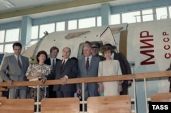 Soviet leader Mikhail Gorbachev (second from right) stands with French President Francois Mitterrand next to a Mir space station simulator in 1986.