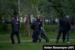 Police officers detain demonstrators protesting plans to construct a cathedral in a park in Yekaterinburg on May 14, 2019.