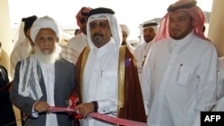 Qatari Assistant Minister for Foreign Affairs Ali bin Fahd al-Hajri (center) and Taliban representative Jan Mohammad Madani (left) at the opening ceremony of the new Taliban political office in Doha, Qatar, on June 18