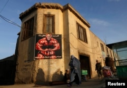 An Afghan woman in a burqa walks past a gym billboard in Kabul. (file photo)