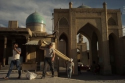 Men carry a carpet into a marketplace in the center of Bukhara that was demolished by the authorities soon after this 2017 photo was taken. The market demolition was part of the controversial “accelerated development” of many historic sites in Uzbekistan.