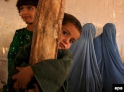 An Afghan refugee family waits outside the United Nation High Commissioner for Refugees office in Karachi.