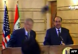 A screen shot shows U.S. President George W. Bush (left) ducking to avoid one of Zaidi's shoes.