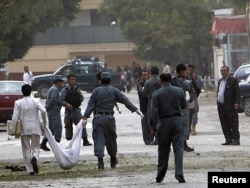 Afghan policemen carry the body of a suicide attacker at the site of a suicide attack in Kabul's embassy district which the United States says was carried out by the Haqqani network.