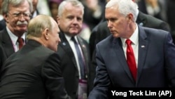 U.S. Vice President Mike Pence (right) shakes hands with Russian President Vladimir Putin during the 13th East Asian Summit Plenary on the sidelines of the 33rd ASEAN summit in Singapore on November 15.