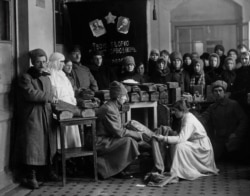 Bread being distributed for Red Army troops beneath portraits of Lenin and Karl Marx.