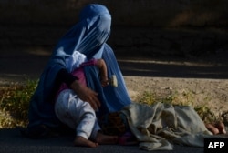 An Afghan woman with her children begs for alms in Herat.