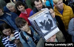 A protester wears a hat depicting Russian President Vladimir Putin and reading "Putin-means stagnation" at a protest rally against unpopular pension reforms in St. Petersburg in 2018.