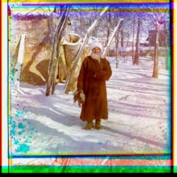 An elderly man -- dressed like an ethnic Tajik -- holds a brace of game birds in Samarkand.