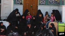 Women and children sit at the shrine of Imam Mussa al-Kadhim in the district of Kadhimiya.