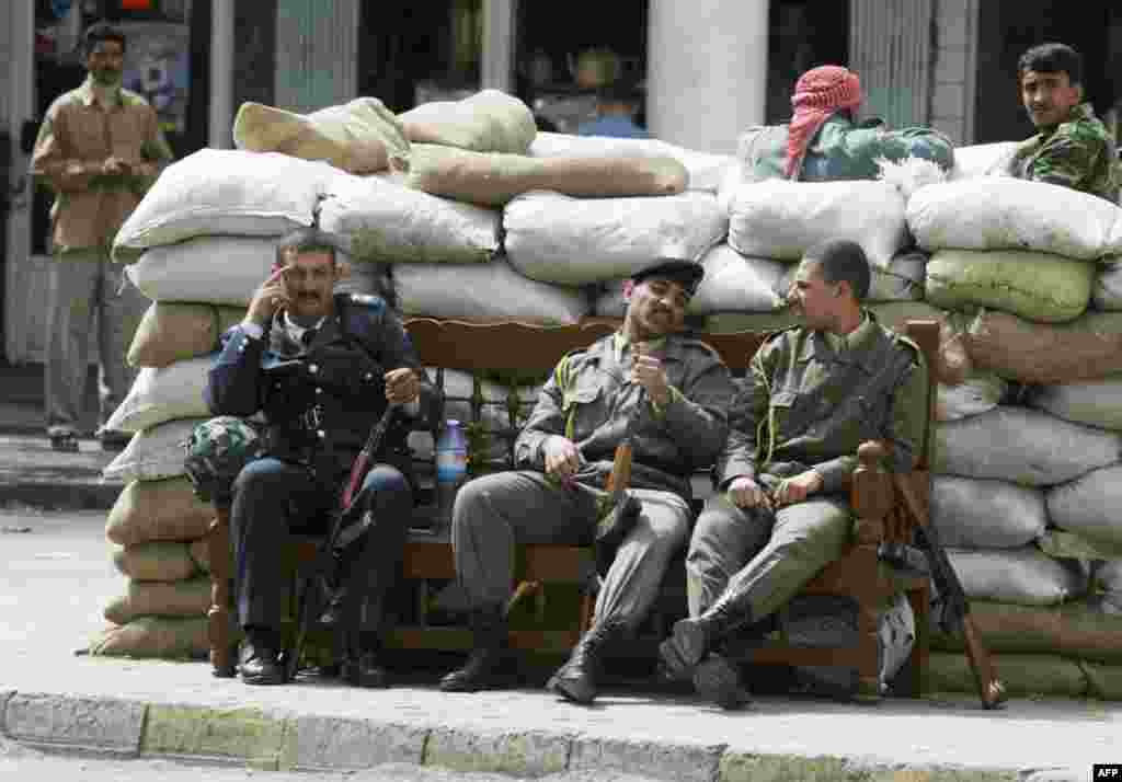 Iraqi militiamen from the ruling Ba&#39;ath party rest in Baghdad amid the U.S. strikes on March 20.