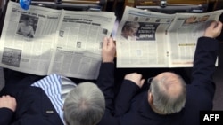 Lawmakers read the newspaper in the parliament in Kyiv.