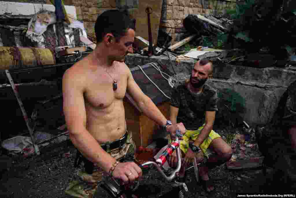 Soldiers known as Dice and Habib hang out in the driveway of a four-story house.