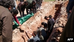 Syrians dig a grave to bury the bodies of some of the 86 victims of a suspected toxic-gas attack in Khan Sheikhun, a nearby rebel-held town in Syria’s northwestern Idlib Province on April 5.