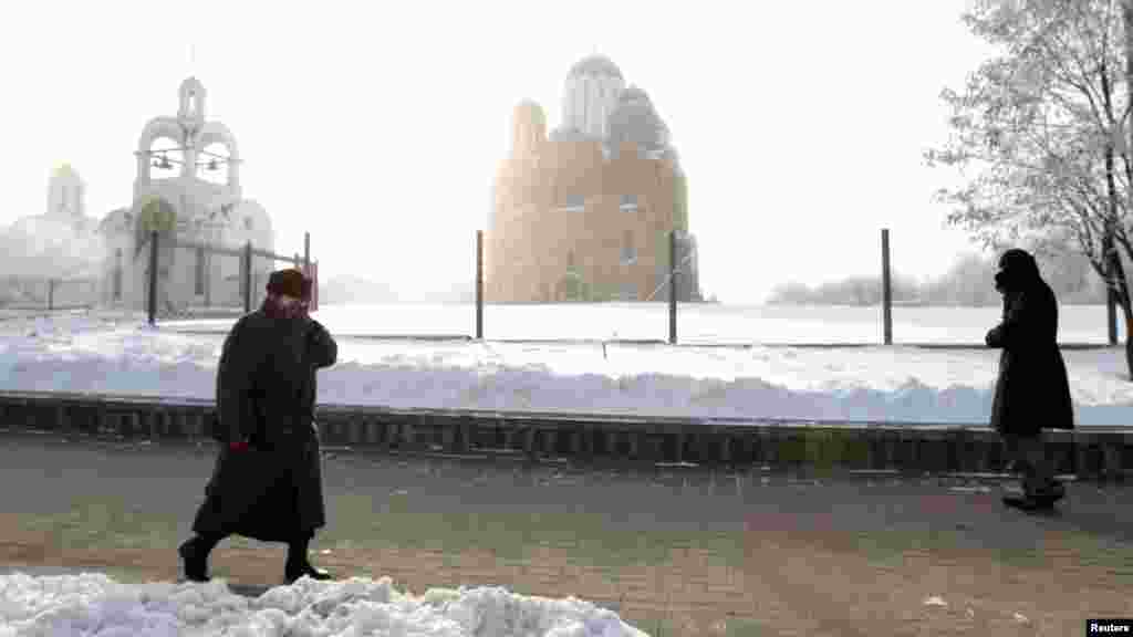 A woman protects her face from frost as she walks in the Belarusian capital, Minsk.