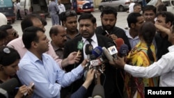 Prosecutor Chaudhry Zulfikar (center) talking to journalists outside a court in Rawalpindi on April 26.