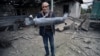 NAGORNO-KARABAKH - A man shows a shell fragment in the yard of his brother's house damaged by shelling during fighting between Armenia and Azerbaijan over the breakaway Nagorno-Karabakh region, in the disputed region's city of Martuni , October 1, 2020