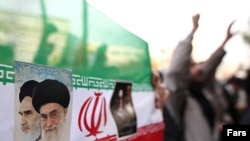 Iranian flag with portraits of Islamic Republic's founder, Ayatollah Ruhollah Khomeini (left), and his successor, Ali Khamenei, at a Tehran protest in mid-December.