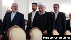 Iranian President Hassan Rohani (center right) walks with Iranian Foreign Minister Mohammad Javad Zarif (left).