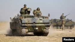 Turkish military armored personnel carriers take positions on the Turkish-Syrian border near the Akcakale border crossing on October 4.