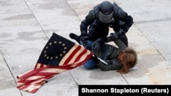 A riot police officer detains a pro-Trump protester as mobs stormed the U.S. Capitol on January 6.