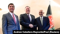 U.S. Secretary of State Mike Pompeo (center) shakes hands with Afghan President Ashraf Ghani as U.S. Secretary of Defense Mark Esper looks on at the Munich Security Conference on February 14. 