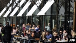 Swedes enjoy a sunny afternoon on the terrace of a bar in Stockholm.